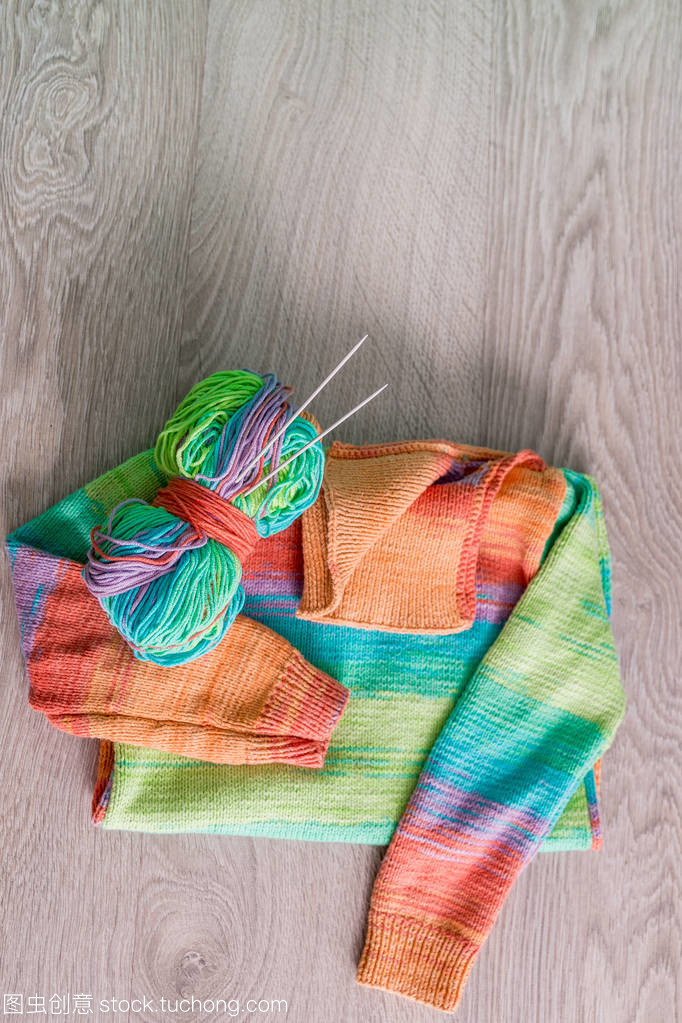 針織。針織毛衫。多色球的紗線用針附近上木制的灰色背景的手工產品。頂視圖。復制空間